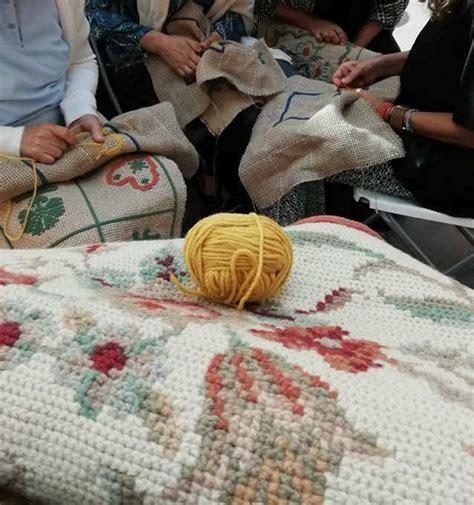 Hands stitching Arraiolos together in a circle