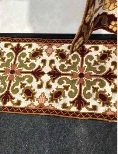 Detail of an ornate finished Arraiolos rug with traditional motifs
