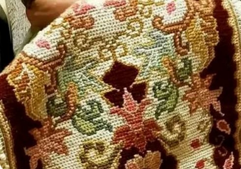 A freshly finished Arraiolos tapestry held up in hands