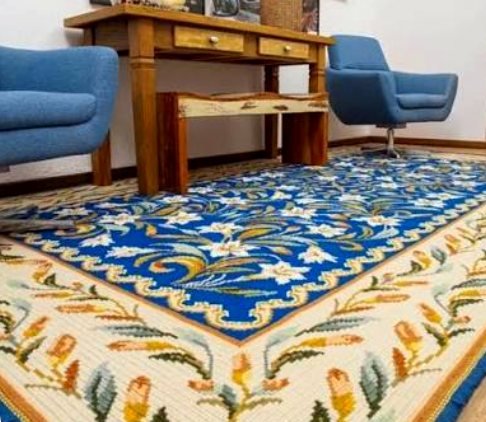 A blue floral Arraiolos rug in a living room
