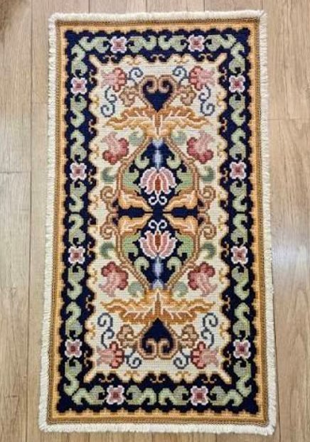 A finished navy and cream Arraiolos rug